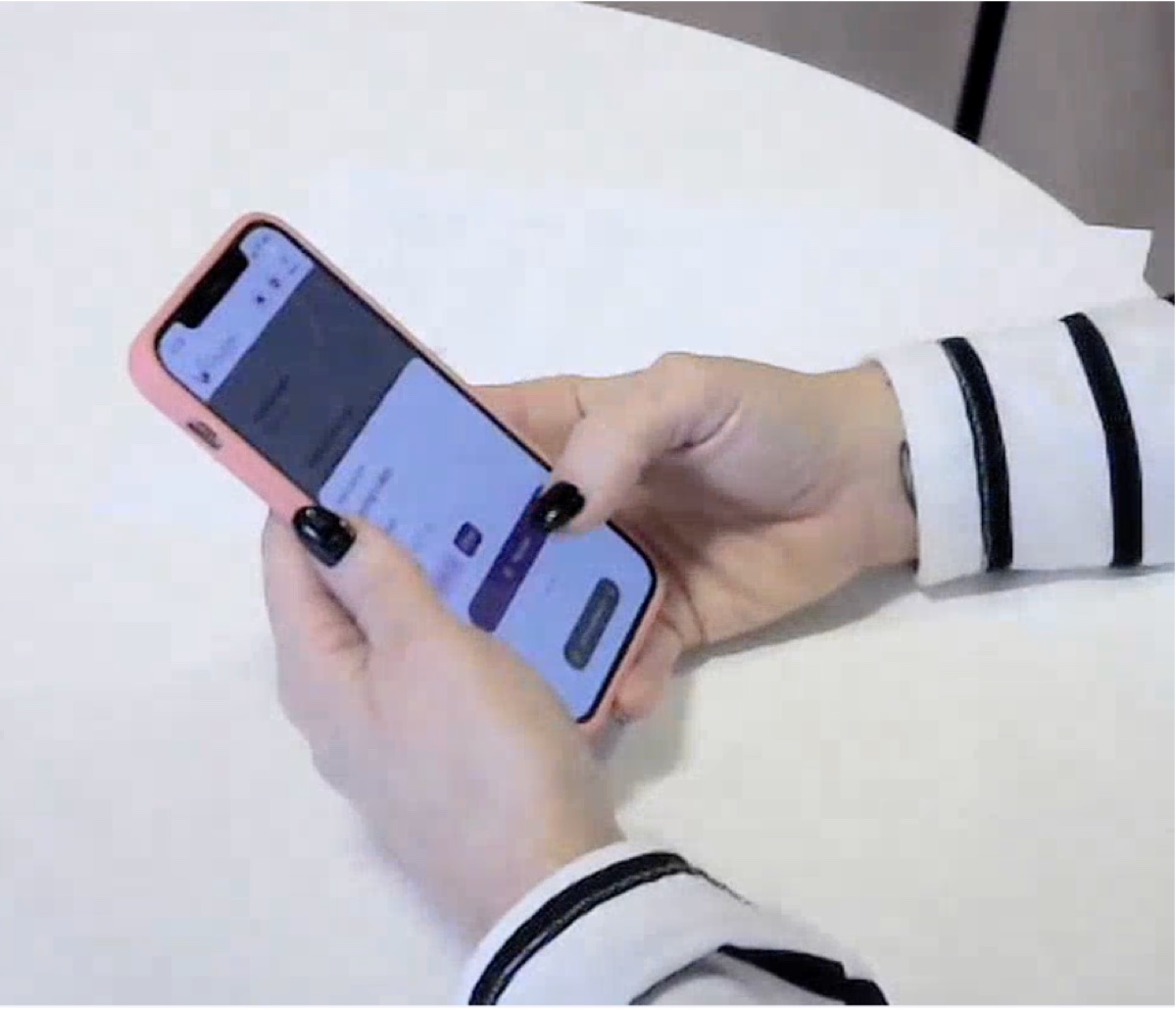 A resident holding a phone and working through a task during a moderated usability session.